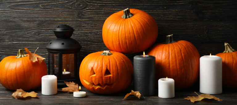 Pumpkins and halloween accessories on wooden background